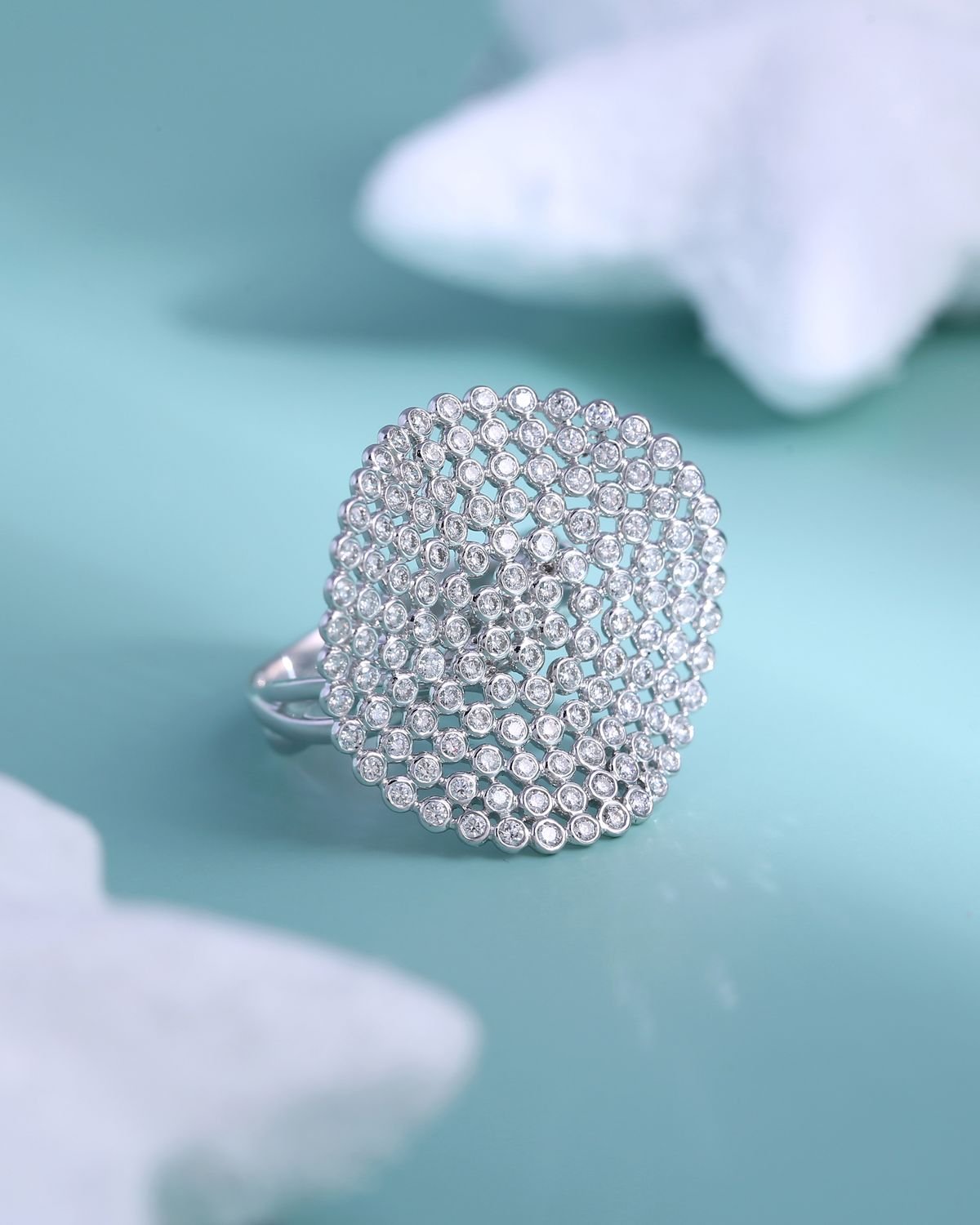 A pavé lab-grown diamond ring set with brilliant-cut diamonds on a teal background